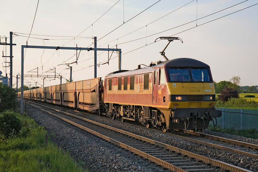 90035, 16.31 Garston-Dagenham (6L48), MIlton Malsor 
 Just over ten minutes after the last car train headed south another one appears! Whilst the first one was carrying hundreds of thousands of pounds worth of JLR vehicles for export, this one is empty having delivered imported Ford cars to their finishing and distribution centre at Garston interestingly adjacent to where the first train originated at Halewood. 90035 leads the 16.31 Garston to Dagenham cartic empties past Milton Malsor on a glorious evening marking the final day of meteorological spring. 
 Keywords: 90035 16.31 Garston-Dagenham 6L48 MIlton Malsor